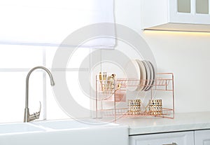 Clean dishes on drying rack in kitchen interior