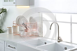 Clean dishes on drying rack in kitchen interior