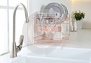 Clean dishes on drying rack in modern kitchen