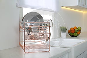 Clean dishes on drying rack in modern kitchen