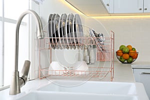 Clean dishes on drying rack in modern kitchen