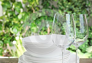 Clean dishes and glasses on wooden table