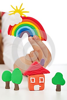 Clean environment concept - child hand with colorful clay figure