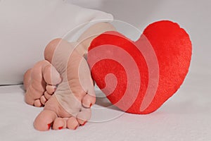 Clean female feet soles with red heart. Love your self, selfcare, footcare concept.