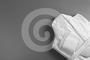 Clean folded bathrobe and slippers on background, top view. Space for text