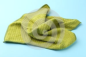 Clean green microfiber cloth on light blue background, closeup