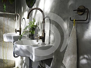 Clean loft style bathroom interior with white modern sink basin and brass faucet.