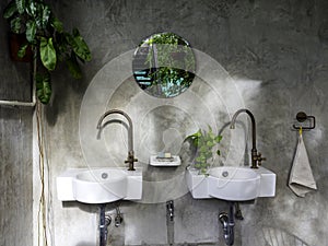 Clean loft style bathroom interior with white modern sink basin and brass faucet.