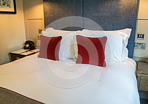 Clean luxury king size bed with many pillows in master hotel room