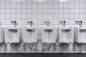 Clean male toilet row of urinals in a public restroom