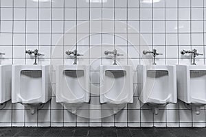 Clean male toilet row of urinals in a public restroom photo