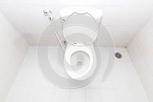 A clean modern toilet bowl and rising spray. Top view white toilet bowl in a bathroom