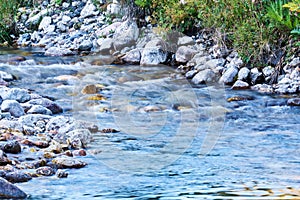 Clean mountain stream in rocky shores blurred in motion