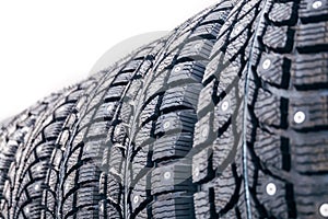 Clean new modern studded winter tires in row. Tires with spikes, close up,