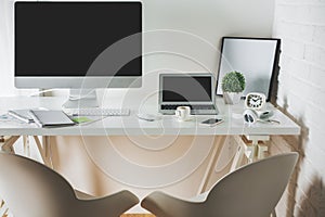 Clean office desk with computer and laptop