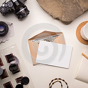 Clean photo card mockup with camera and old negative film rolls on white background