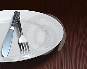 Clean plate & cutlery on dark woodgrain table