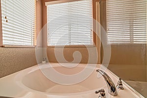 Clean polished built in round bathtub with stainless steel faucet fixture