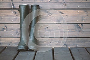 Clean rubber boots on a wooden background. The concept of the garden work.