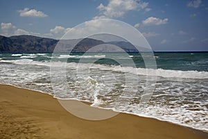 Clean sandy Georgioupolis beach, azure Mediterranean sea, mountains on the horison