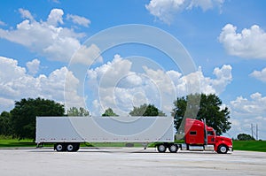 Clean shiny red semi tractor truck w cargo trailer