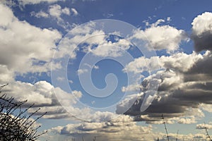 Clean sky with air fluffy clouds and rain behind on sunset as beautiful background