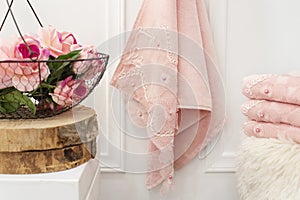 Clean soft pink towels with lace and pearls. Flowers on background