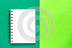 Clean spiral note book for notes on green background. Minimal business flat lay mock up