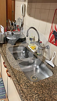Clean stainless kitchen sink with dishes.