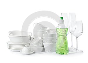 Clean tableware and bottle of detergent on white background