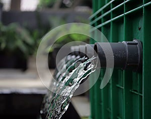 Clean water flows in a pipe after being filtered in a fish pond