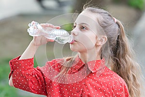 Clean water is a vital resource for human existence. Little girl having a drop of water. Thirsty child drinking fresh