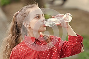 Clean water is a vital resource for human existence. Little girl having a drop of water. Thirsty child drinking fresh