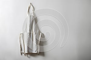 Clean white apron hanging neatly, symbolizing simplicity and functionality for culinary use photo