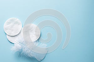 Clean white cotton stack of disk for beauty face hygiene with selective focus on blue neutral background. Cosmetic softness pure