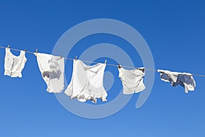Clean white laundry drying in the sun