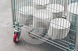 Clean white plater in a metal cart