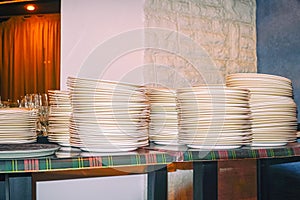 Clean white plates stacked on table