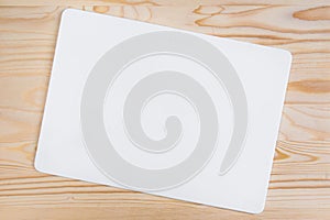 Clean white sheet with rounded edges on a light-colored wooden background