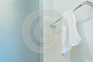 Clean white towel on a hanger in bathroom