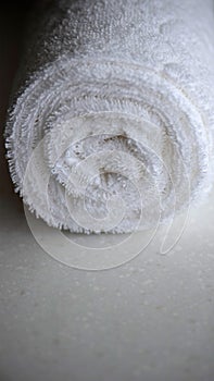 Clean white towel rolled blanket textile on a marble countertop