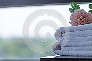 Clean white towels are folded beside bed to be ready for customers to use when it`s time to take shower because towels are