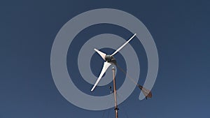 Clean wind energy generation. Efficient wind turbine rotate on blue sky