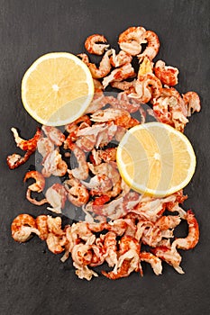 Cleaned and cooked crayfish tails with lemon on slate photo
