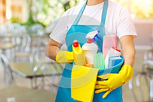 Cleaner with cleaning products in hand .