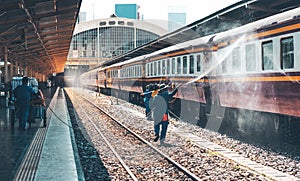 Cleaner Helping to clean the locomotives Which is parked on the platfrom With high-pressure water injection