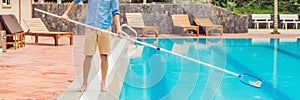 Cleaner of the swimming pool . Man in a blue shirt with cleaning equipment for swimming pools, sunny BANNER, long format