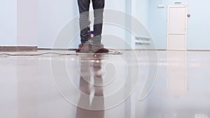 The cleaner washes a pier with a professional polisher machine. Cleaning floor in office building lobby