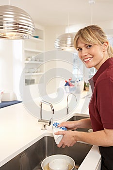 Cleaner Working In Domestic Kitchen