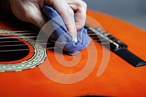 Cleaning the acoustic guitar body with a clean rag